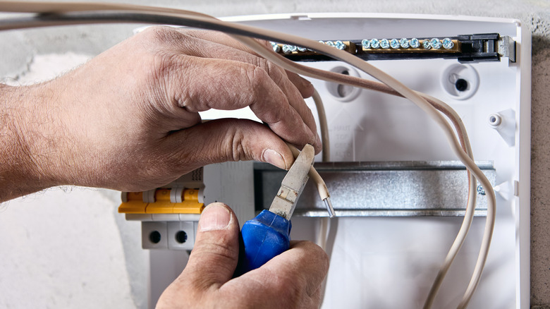 person working with aluminum wiring in electrical panel