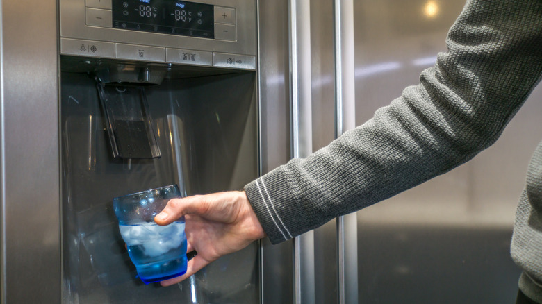 man filling cup with ice