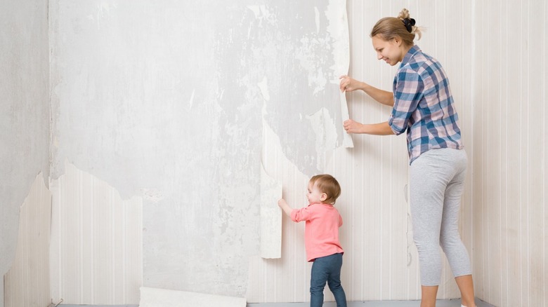 woman and child removing wallpaper