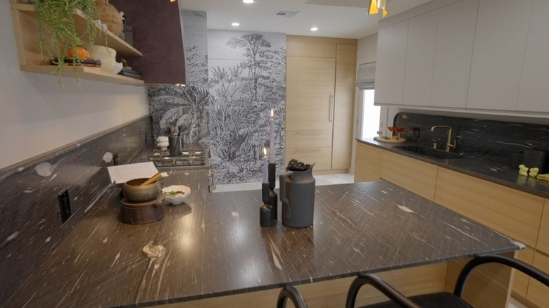 A kitchen with black countertops and sleek cabinets