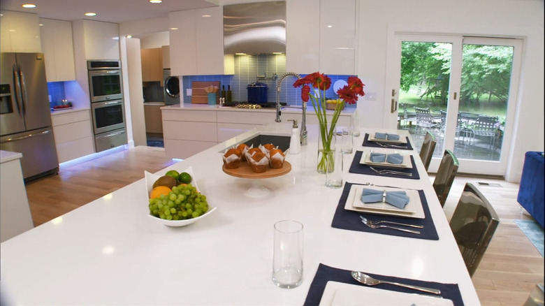 An all-white kitchen with a blue backsplash.