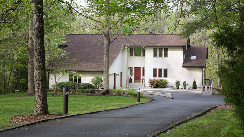 An exterior of a home with a long front driveway.