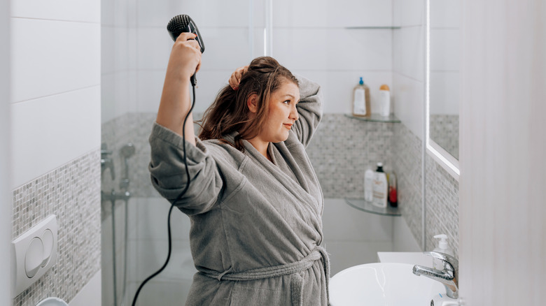 woman drying hair in bathroom