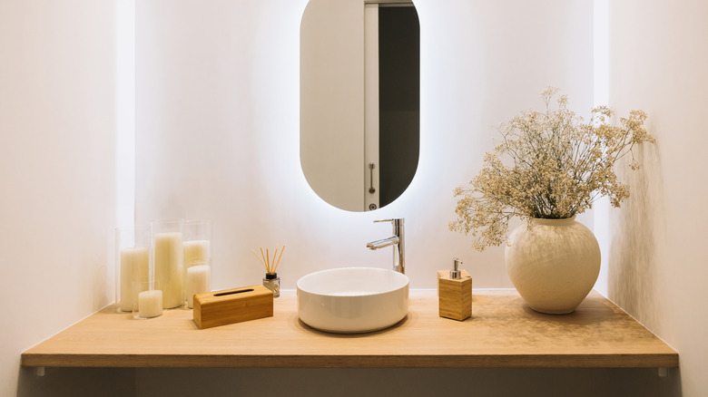 A modern, minimalist bathroom vanity with a round sink.