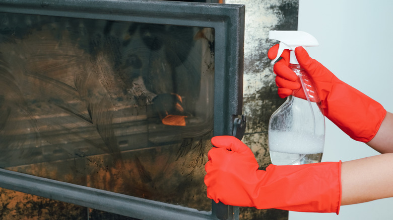 Person cleaning a wood-burning fireplace