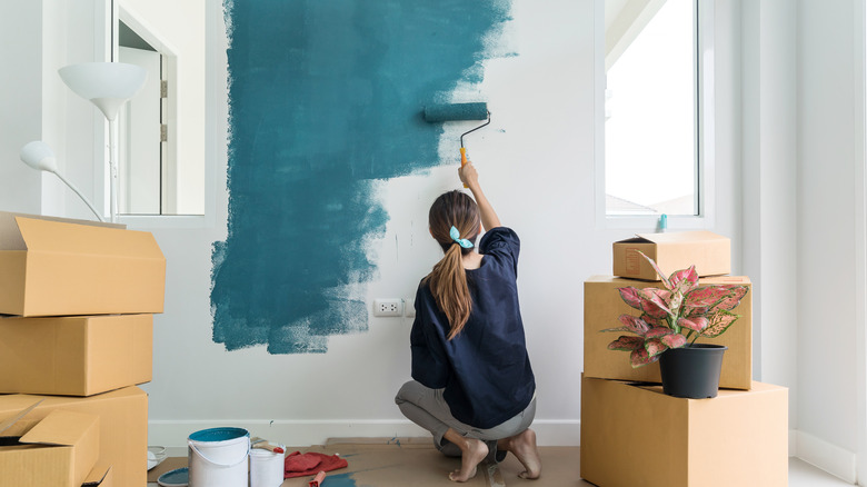 Woman painting wall blue