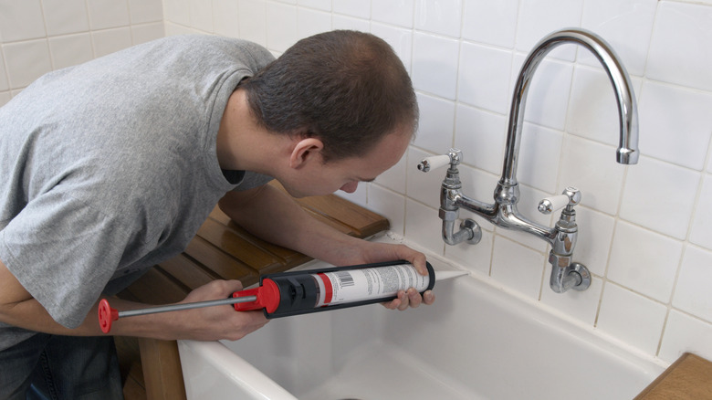 man fixing wall-mounted faucet