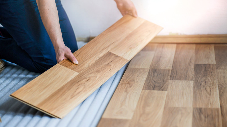 person installing laminate floor planks