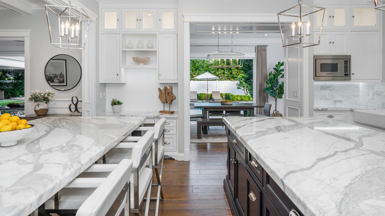 A large white luxury kitchen with white marble countertops