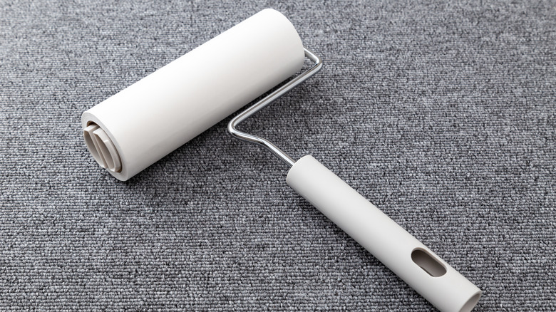 A lint roller on a grey carpet