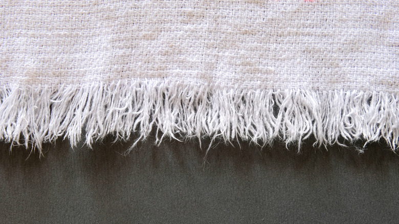 Frayed white fabric on black background