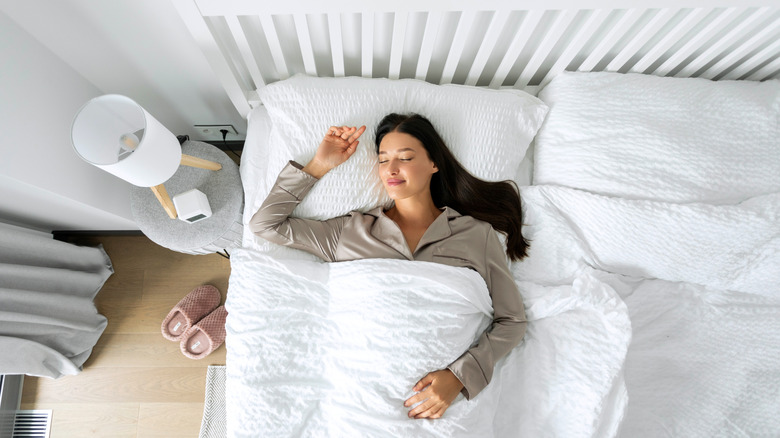 Woman smiling, looking relaxed and comfortable while lying in bed