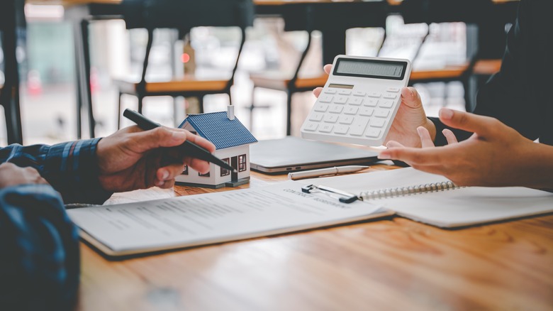 Person with pen calculating mortgage