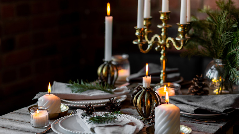 Christmas table with vintage brass candle holders and pinecones