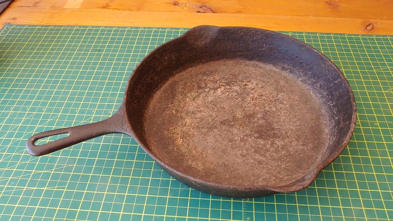 A cast iron pan face-up on a rubber mat