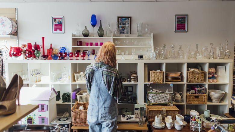 Woman looking at glass at thrift store