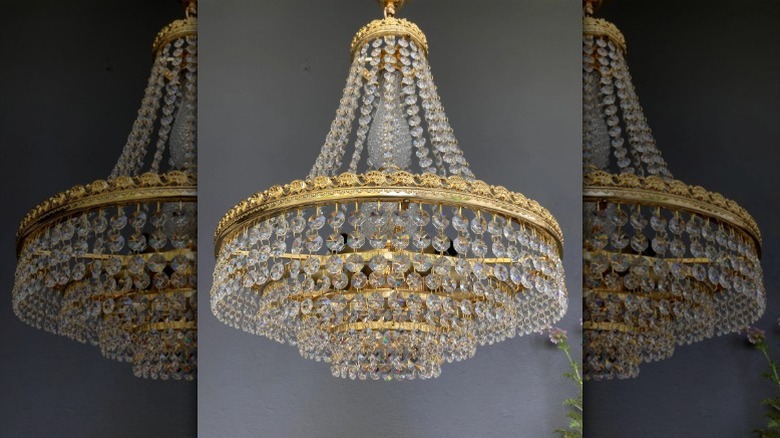 A vintage Swarovski chandelier from the 1960s hanging in a room with gray-painted walls.
