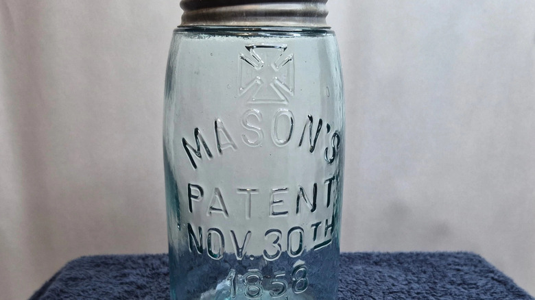 a light blue Mason jar featuring the hero's cross
