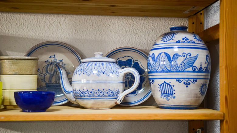 Assorted antique pottery on a wooden shelf