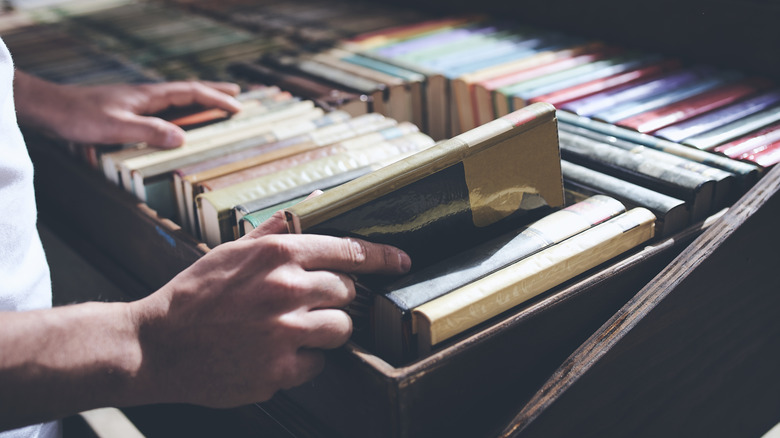 Man choosing a book out of a thrift store bin