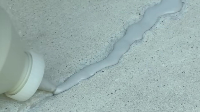 Someone filling a crack with a sealant