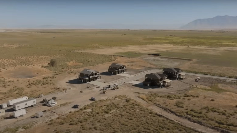 Four black modern houses in the desert.