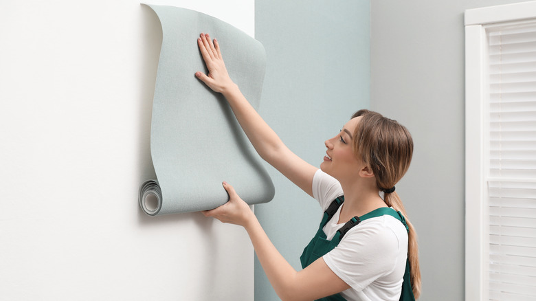 Woman applying wallpaper