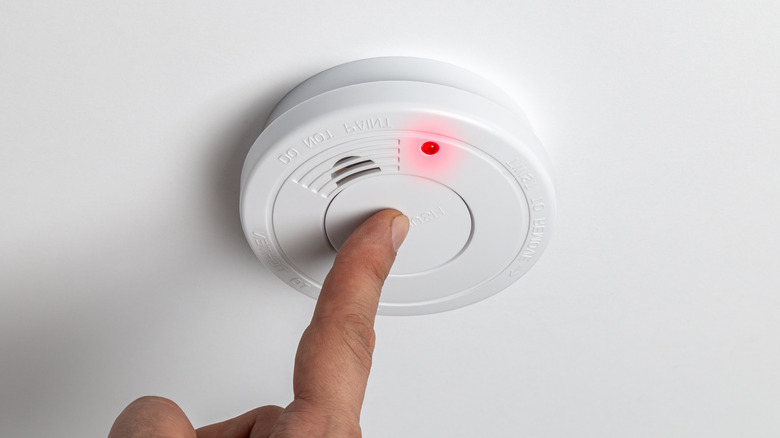 man checking smoke alarm