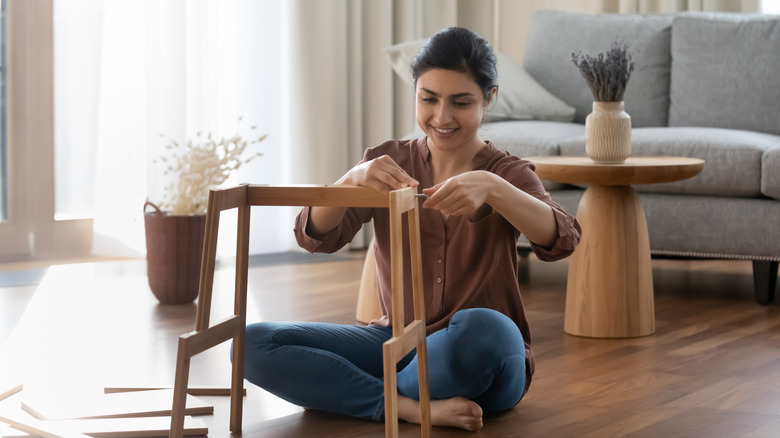 woman assembling wood furniture