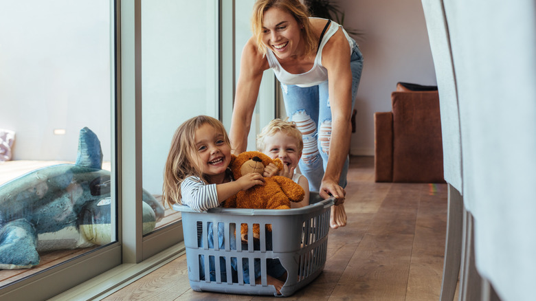 mom pushing kids in laundry basket 