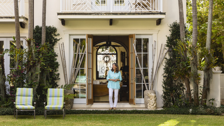 Woman standing between open front doors