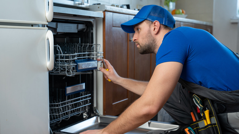 technician diagnosing a dishwasher