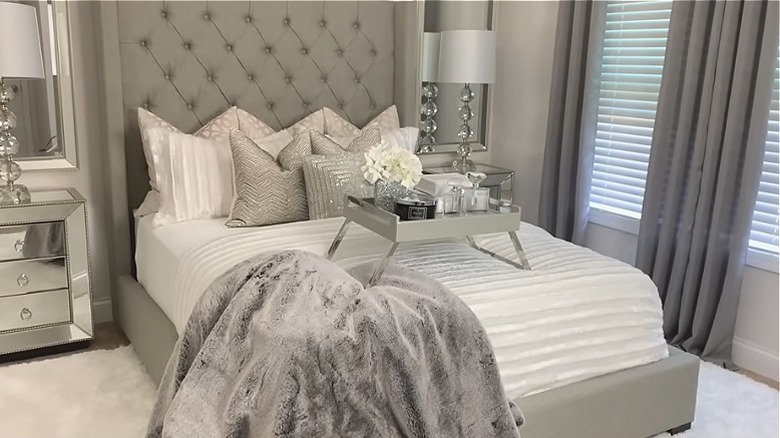A luxurious bedroom with all white, gray, and chrome furniture.