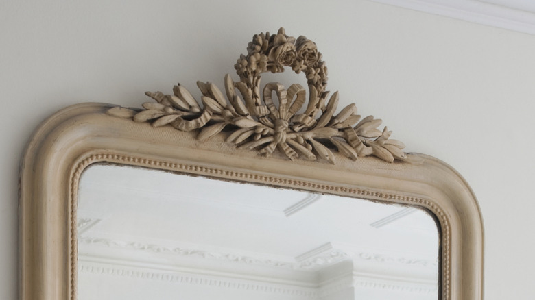 The top of a Gustavian style mirror with carved rosettes