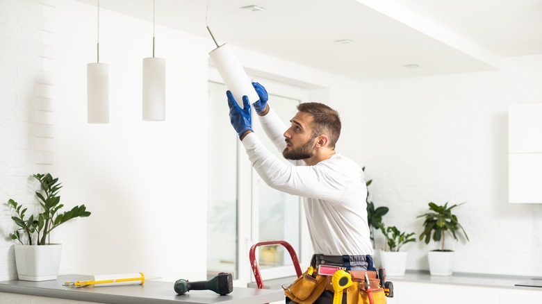 electrician installing overhead lighting