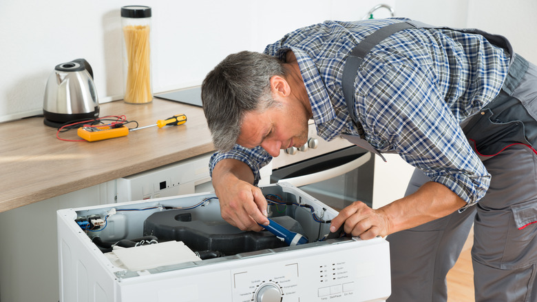 technician fixing washing machine