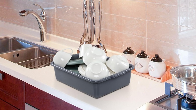 Bus tub holding dishes on a counter