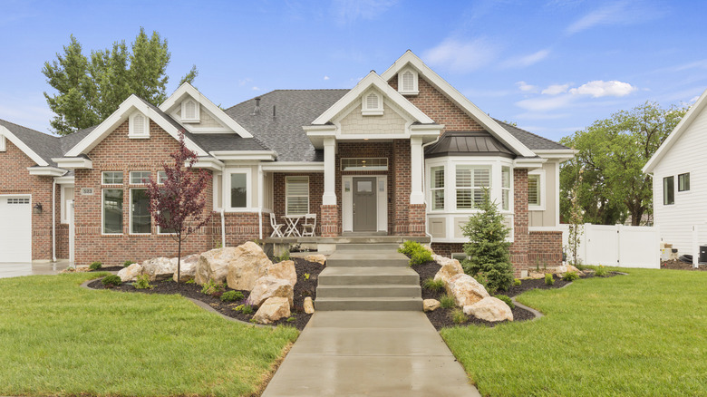 large boulders lead to the front walkway of a home