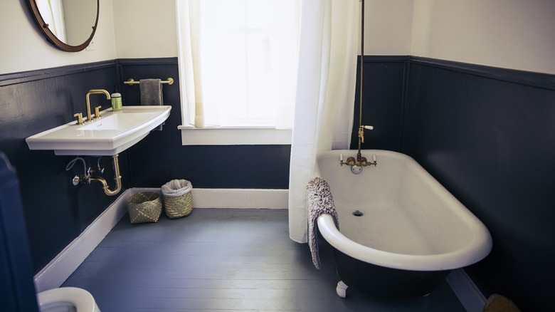 A navy and white bathroom with a freestanding tub
