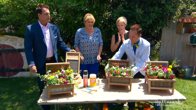 two men and two women admiring antique washboards turned into charming planters shaped like beds