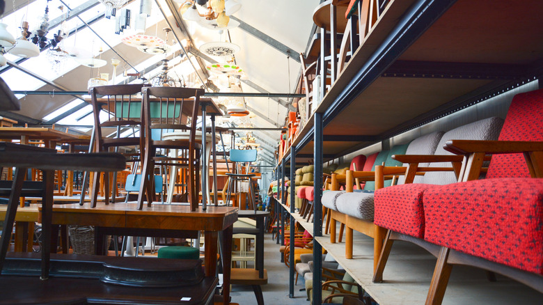 A selection of retro furniture pieces adorn the sales floor in a secondhand warehouse.