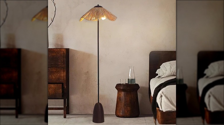 Slender floor lamp with rattan shade in bedroom