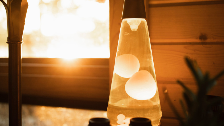 An earthy-toned lava lamp creating a warm, natural glow next to a window