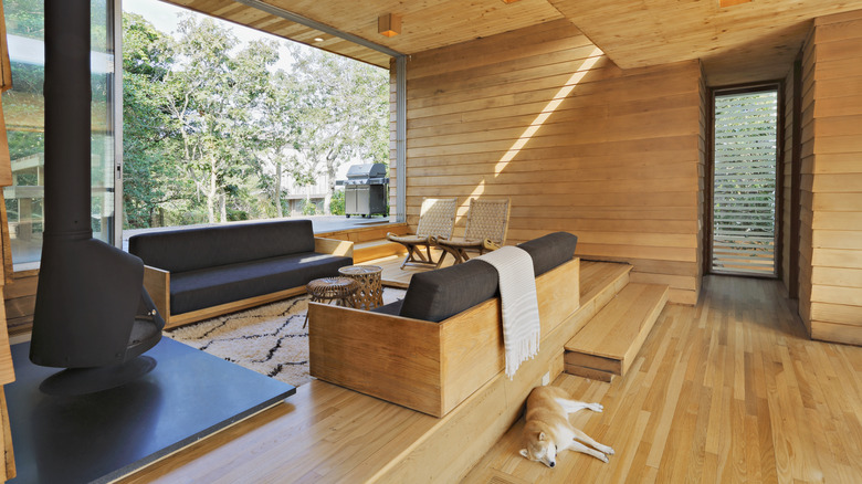 Modern home with a sunken pit feel with sofas facing each other rugs and a fireplace