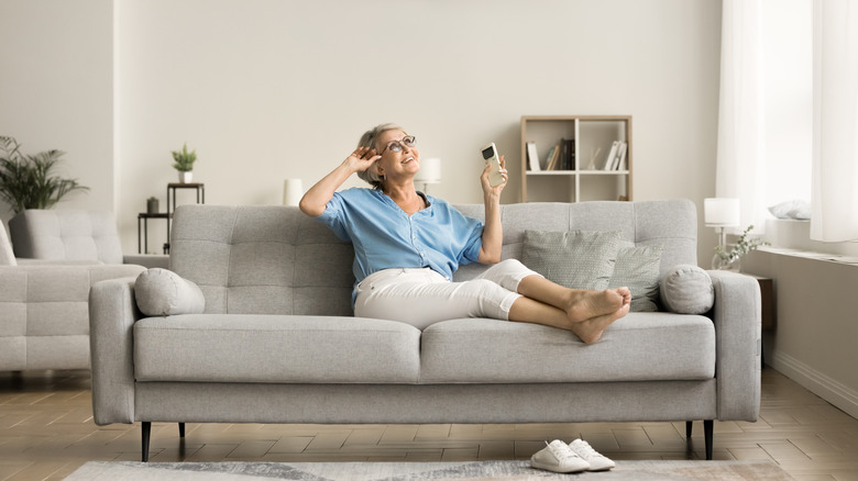 Woman relaxing on couch with white walls