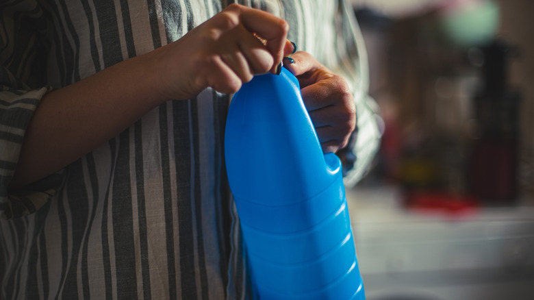 person holding bottle of bleach