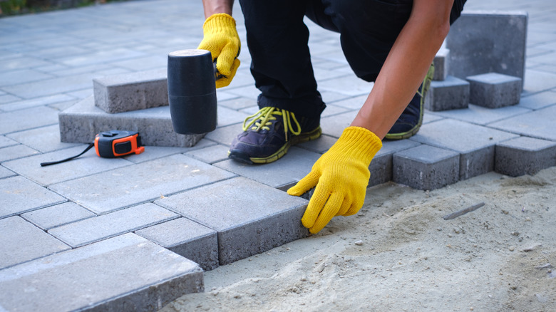 Person laying concrete pavers