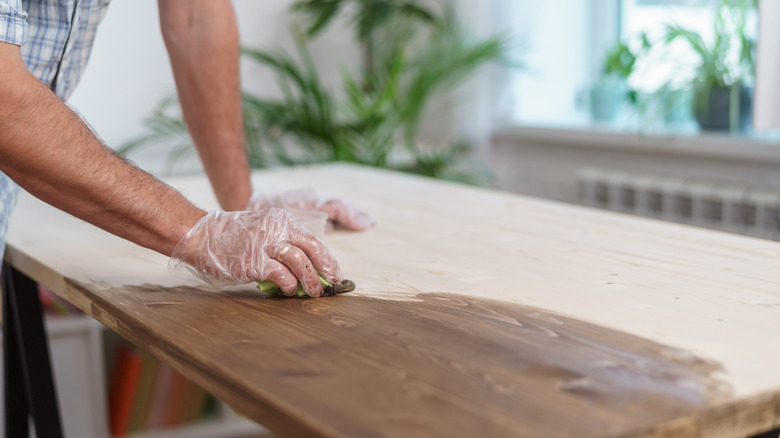 Applying wood stain with rag