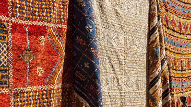 Three patterned tapestries hanging alongside each other