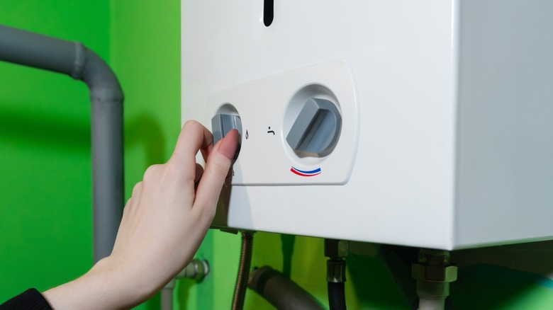A woman adjusting the settings on a combi boiler
